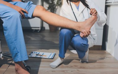 Fizyoterapist hastaya diz ağrısı için egzersiz yapmayı öğretiyor.