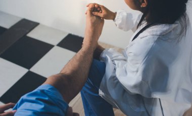 Fizyoterapist hastaya diz ağrısı için egzersiz yapmayı öğretiyor.