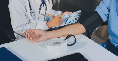 Hastanedeki hastanın kan basıncını ölçen doktor. Sağlık Hizmetleri Konsepti