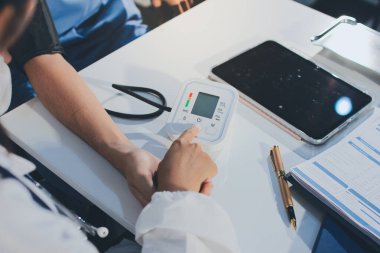 Hastanedeki hastanın kan basıncını ölçen doktor. Sağlık Hizmetleri Konsepti