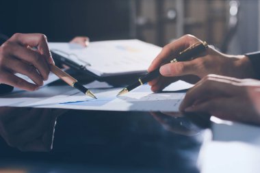 Gözlüklü yetenekli bir avukatla anlaşma imzalamaya odaklanmış genç bir işadamı. Konsantre mali danışman, ofiste erkek müşteriye sözleşme belgesinde imza yeri gösteriyor.