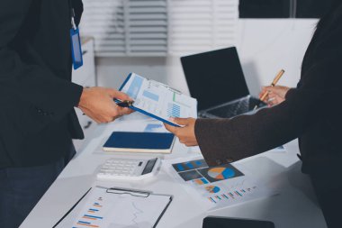 Gözlüklü yetenekli bir avukatla anlaşma imzalamaya odaklanmış genç bir işadamı. Konsantre mali danışman, ofiste erkek müşteriye sözleşme belgesinde imza yeri gösteriyor.