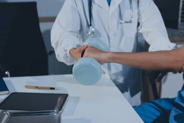 Hemşirenin desteğiyle el ağırlığı kullanan kişi