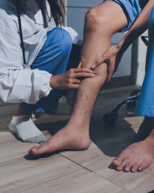 Fizyoterapist hastaya diz ağrısı için egzersiz yapmayı öğretiyor.