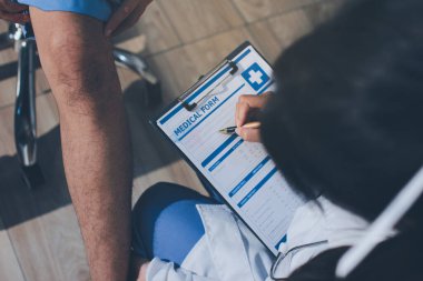 Fizyoterapist hastaya diz ağrısı için egzersiz yapmayı öğretiyor.