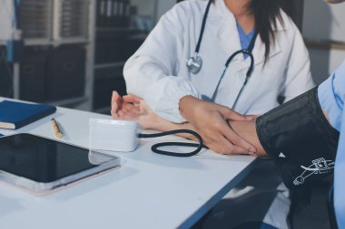 Hastanedeki hastanın kan basıncını ölçen doktor. Sağlık Hizmetleri Konsepti