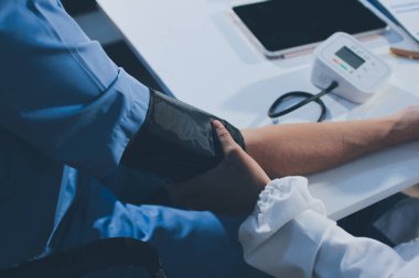 Hastanedeki hastanın kan basıncını ölçen doktor. Sağlık Hizmetleri Konsepti