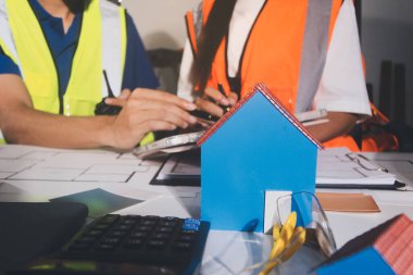 Endüstriyel mühendislerden oluşan bir ekip, fabrikadaki masada bulunan makine planlarını analiz ediyor. Fabrikada ya da üretim tesisinde çalışıyorum..