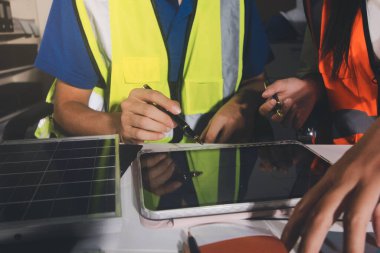 Endüstriyel mühendislerden oluşan bir ekip, fabrikadaki masada bulunan makine planlarını analiz ediyor. Fabrikada ya da üretim tesisinde çalışıyorum..