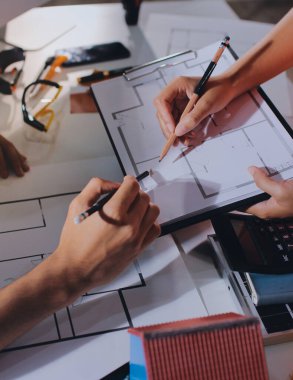 Endüstriyel mühendislerden oluşan bir ekip, fabrikadaki masada bulunan makine planlarını analiz ediyor. Fabrikada ya da üretim tesisinde çalışıyorum..