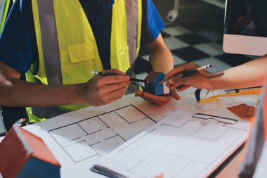 Endüstriyel mühendislerden oluşan bir ekip, fabrikadaki masada bulunan makine planlarını analiz ediyor. Fabrikada ya da üretim tesisinde çalışıyorum..