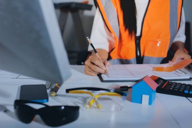 Endüstriyel mühendislerden oluşan bir ekip, fabrikadaki masada bulunan makine planlarını analiz ediyor. Fabrikada ya da üretim tesisinde çalışıyorum..
