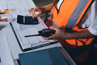 Endüstriyel mühendislerden oluşan bir ekip, fabrikadaki masada bulunan makine planlarını analiz ediyor. Fabrikada ya da üretim tesisinde çalışıyorum..