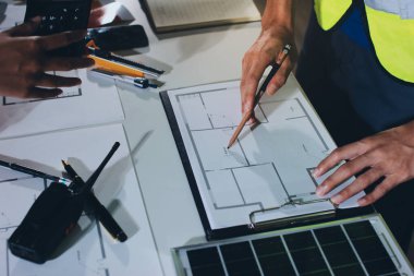 Endüstriyel mühendislerden oluşan bir ekip, fabrikadaki masada bulunan makine planlarını analiz ediyor. Fabrikada ya da üretim tesisinde çalışıyorum..