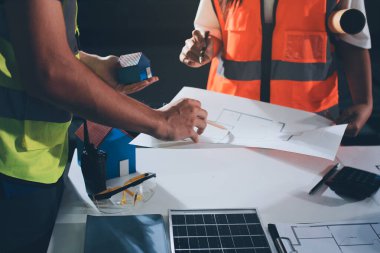 Endüstriyel mühendislerden oluşan bir ekip, fabrikadaki masada bulunan makine planlarını analiz ediyor. Fabrikada ya da üretim tesisinde çalışıyorum..