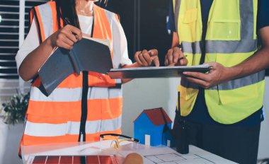 Endüstriyel mühendislerden oluşan bir ekip, fabrikadaki masada bulunan makine planlarını analiz ediyor. Fabrikada ya da üretim tesisinde çalışıyorum..