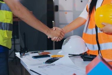 Endüstriyel mühendislerden oluşan bir ekip, fabrikadaki masada bulunan makine planlarını analiz ediyor. Fabrikada ya da üretim tesisinde çalışıyorum..