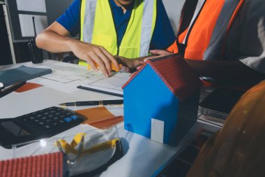 Endüstriyel mühendislerden oluşan bir ekip, fabrikadaki masada bulunan makine planlarını analiz ediyor. Fabrikada ya da üretim tesisinde çalışıyorum..