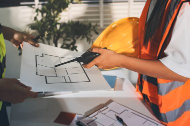 Endüstriyel mühendislerden oluşan bir ekip, fabrikadaki masada bulunan makine planlarını analiz ediyor. Fabrikada ya da üretim tesisinde çalışıyorum..