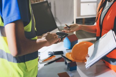 Endüstriyel mühendislerden oluşan bir ekip, fabrikadaki masada bulunan makine planlarını analiz ediyor. Fabrikada ya da üretim tesisinde çalışıyorum..
