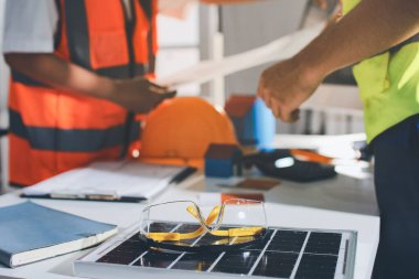 Endüstriyel mühendislerden oluşan bir ekip, fabrikadaki masada bulunan makine planlarını analiz ediyor. Fabrikada ya da üretim tesisinde çalışıyorum..