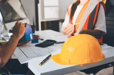 Endüstriyel mühendislerden oluşan bir ekip, fabrikadaki masada bulunan makine planlarını analiz ediyor. Fabrikada ya da üretim tesisinde çalışıyorum..