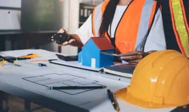 Endüstriyel mühendislerden oluşan bir ekip, fabrikadaki masada bulunan makine planlarını analiz ediyor. Fabrikada ya da üretim tesisinde çalışıyorum..