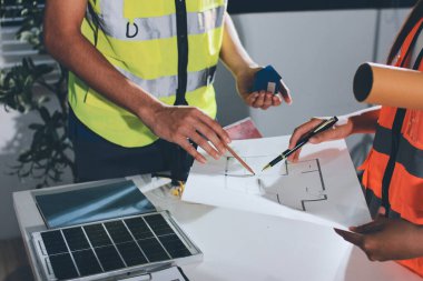 Endüstriyel mühendislerden oluşan bir ekip, fabrikadaki masada bulunan makine planlarını analiz ediyor. Fabrikada ya da üretim tesisinde çalışıyorum..