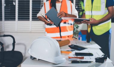 Endüstriyel mühendislerden oluşan bir ekip, fabrikadaki masada bulunan makine planlarını analiz ediyor. Fabrikada ya da üretim tesisinde çalışıyorum..