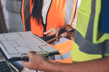 Endüstriyel mühendislerden oluşan bir ekip, fabrikadaki masada bulunan makine planlarını analiz ediyor. Fabrikada ya da üretim tesisinde çalışıyorum..
