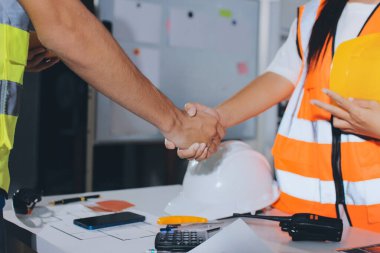 Endüstriyel mühendislerden oluşan bir ekip, fabrikadaki masada bulunan makine planlarını analiz ediyor. Fabrikada ya da üretim tesisinde çalışıyorum..