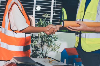 Endüstriyel mühendislerden oluşan bir ekip, fabrikadaki masada bulunan makine planlarını analiz ediyor. Fabrikada ya da üretim tesisinde çalışıyorum..