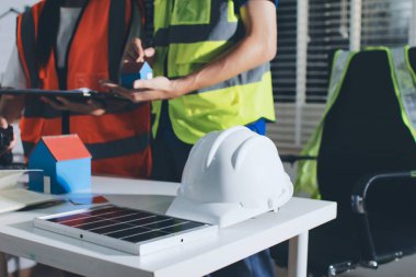 Endüstriyel mühendislerden oluşan bir ekip, fabrikadaki masada bulunan makine planlarını analiz ediyor. Fabrikada ya da üretim tesisinde çalışıyorum..