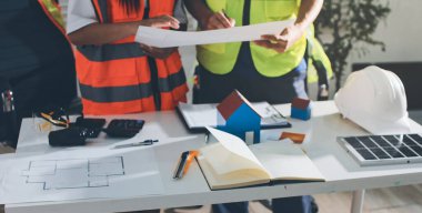 Endüstriyel mühendislerden oluşan bir ekip, fabrikadaki masada bulunan makine planlarını analiz ediyor. Fabrikada ya da üretim tesisinde çalışıyorum..