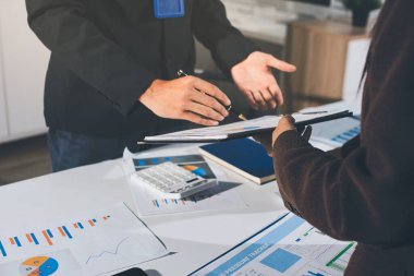 Gözlüklü yetenekli bir avukatla anlaşma imzalamaya odaklanmış genç bir işadamı. Konsantre mali danışman, ofiste erkek müşteriye sözleşme belgesinde imza yeri gösteriyor.