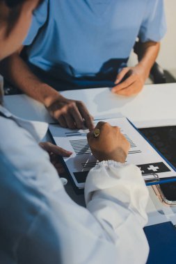 Genç esmer kadın doktor muayenehanesinde muayene oluyor.