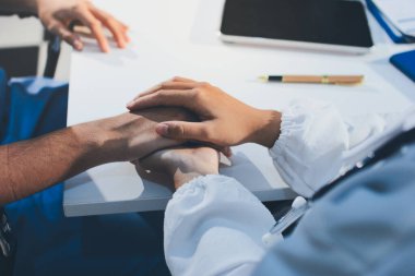 Doktor hastayı kontrol etmeye geldi ve cesaretlendirmek için elini sıktı. Hastanede tedavi edilenleri ve hastaları teselli etmek..