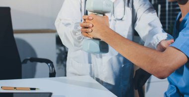 Hemşirenin desteğiyle el ağırlığı kullanan kişi