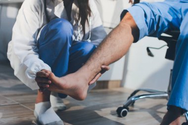 Fizyoterapist hastaya diz ağrısı için egzersiz yapmayı öğretiyor.