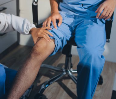 Fizyoterapist hastaya diz ağrısı için egzersiz yapmayı öğretiyor.