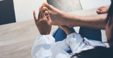 Fizyoterapist hastaya diz ağrısı için egzersiz yapmayı öğretiyor.