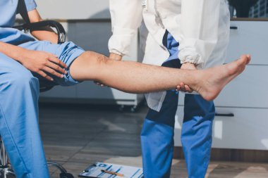 Fizyoterapist hastaya diz ağrısı için egzersiz yapmayı öğretiyor.