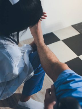 Fizyoterapist hastaya diz ağrısı için egzersiz yapmayı öğretiyor.