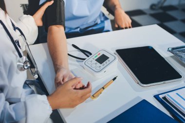 Hastanedeki hastanın kan basıncını ölçen doktor. Sağlık Hizmetleri Konsepti