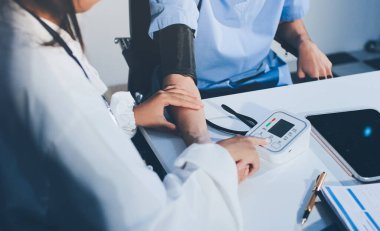 Hastanedeki hastanın kan basıncını ölçen doktor. Sağlık Hizmetleri Konsepti