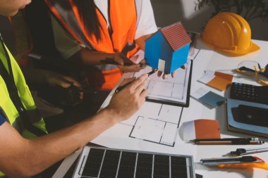 Endüstriyel mühendislerden oluşan bir ekip, fabrikadaki masada bulunan makine planlarını analiz ediyor. Fabrikada ya da üretim tesisinde çalışıyorum..