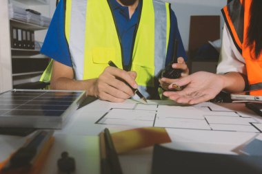 Endüstriyel mühendislerden oluşan bir ekip, fabrikadaki masada bulunan makine planlarını analiz ediyor. Fabrikada ya da üretim tesisinde çalışıyorum..
