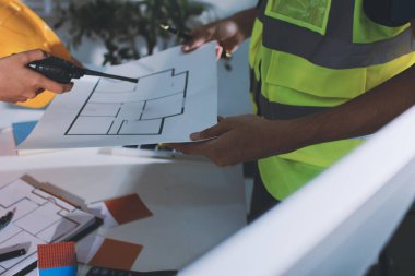 Endüstriyel mühendislerden oluşan bir ekip, fabrikadaki masada bulunan makine planlarını analiz ediyor. Fabrikada ya da üretim tesisinde çalışıyorum..
