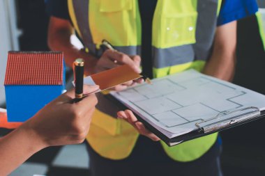 Endüstriyel mühendislerden oluşan bir ekip, fabrikadaki masada bulunan makine planlarını analiz ediyor. Fabrikada ya da üretim tesisinde çalışıyorum..