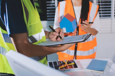 Endüstriyel mühendislerden oluşan bir ekip, fabrikadaki masada bulunan makine planlarını analiz ediyor. Fabrikada ya da üretim tesisinde çalışıyorum..
